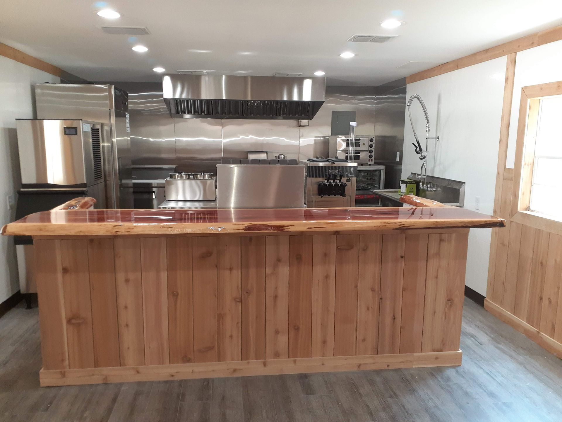A large wooden counter in a kitchen with stainless steel appliances.