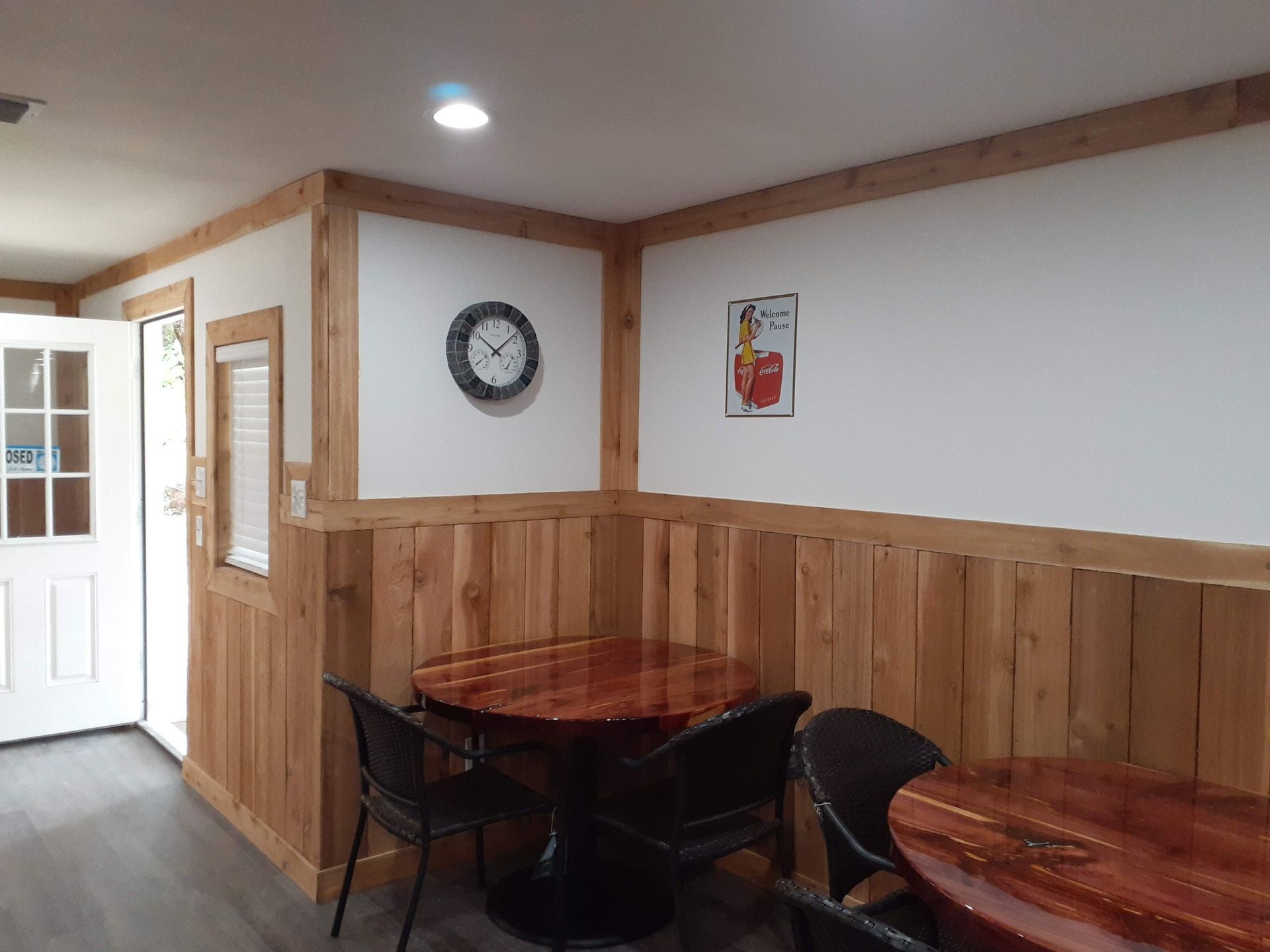 A room with tables and chairs and a clock on the wall.