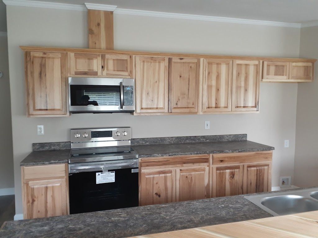 A kitchen with wooden cabinets and a granite counter top.
