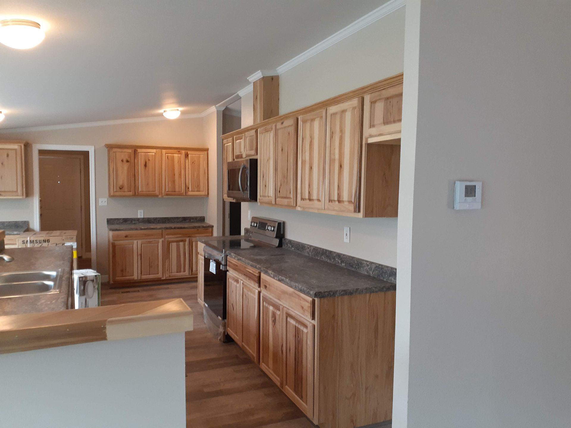 A kitchen in a house with wooden cabinets and granite counter tops.