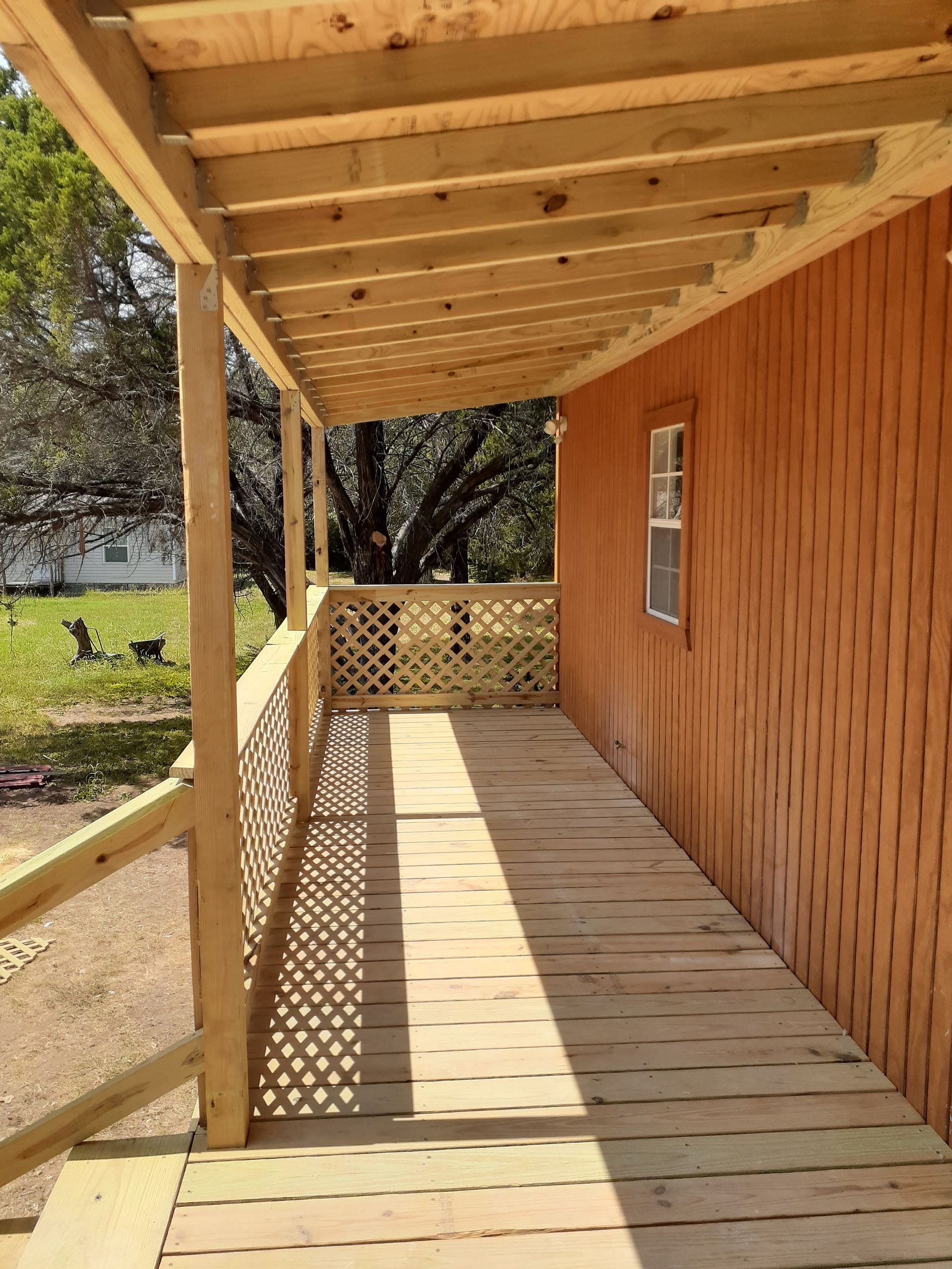 A wooden walkway leading to a house with a window