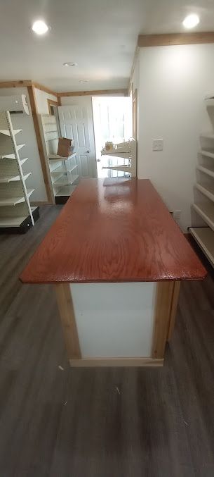 There is a long red table in the middle of a room.