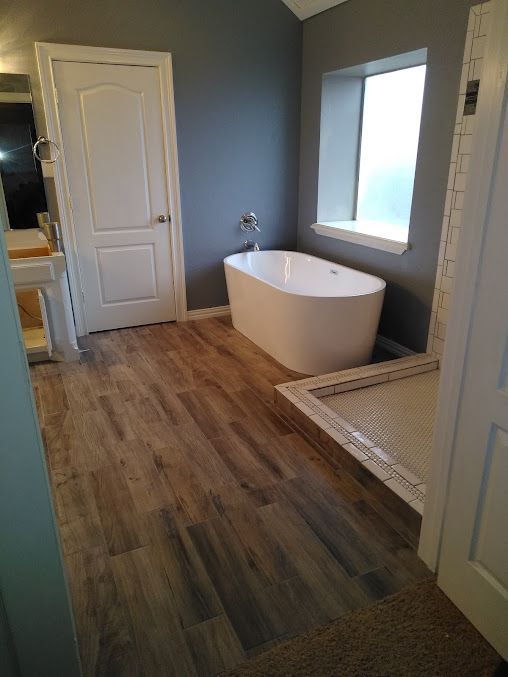 A bathroom with a tub , sink , and shower.