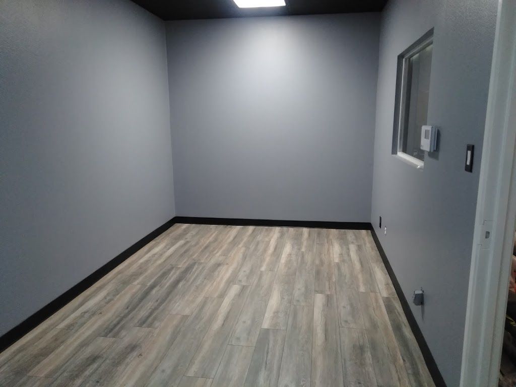 A man is painting a wall in a living room next to a ladder.