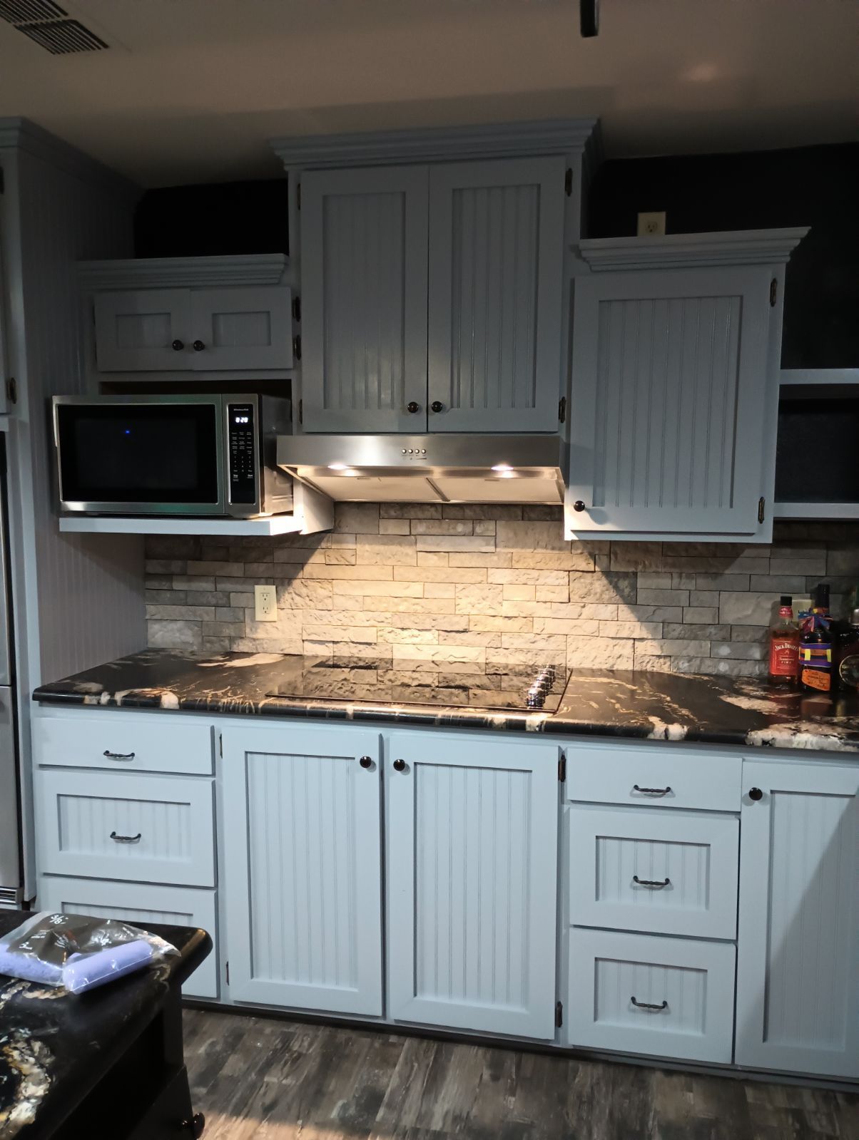 An empty kitchen with wooden cabinets , granite counter tops , and stainless steel appliances.