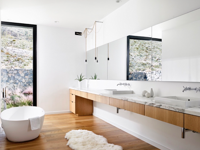 A bathroom with a bathtub , sinks , mirrors and a window.