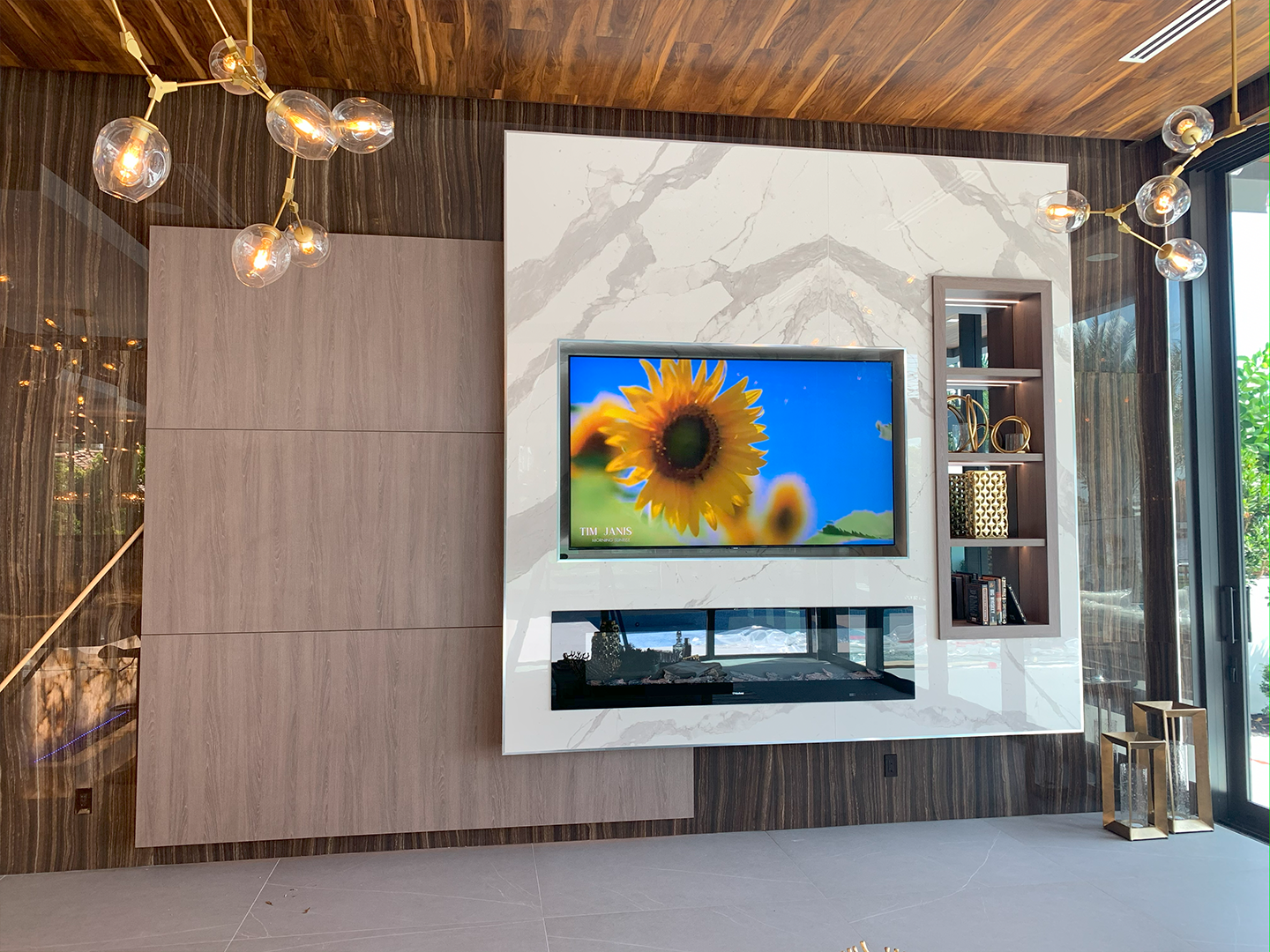 A living room with a fireplace and a flat screen tv on the wall.