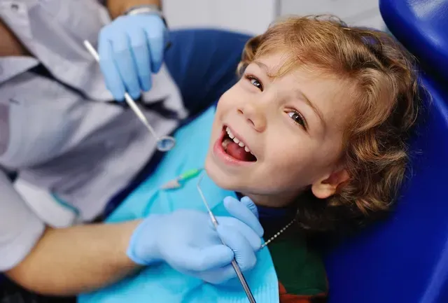 Boy in Dental Chair With Mouth Open, Smiling at Dentist — Tamworth Orthocare In Tamworth, NSW