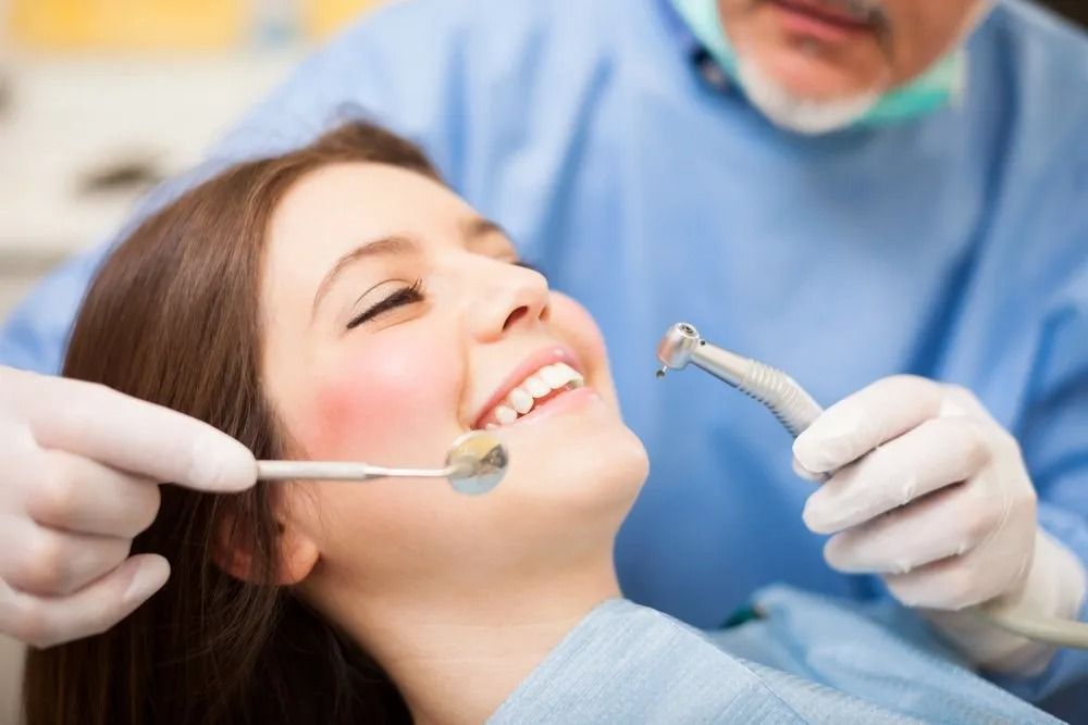 Dentist Examining a Patient's Teeth With Dental Tools in a Dental Office — Tamworth Orthocare In Tamworth, NSW