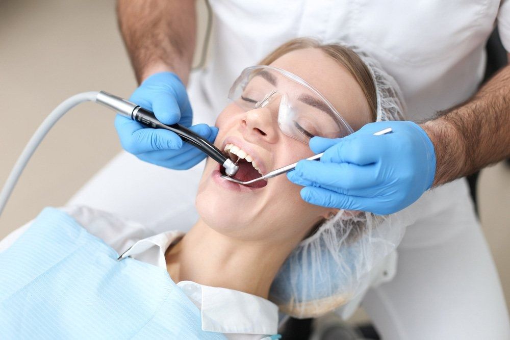 Dentist Performing Dental Cleaning on a Patient in a Clinic Setting — Tamworth Orthocare In Tamworth, NSW