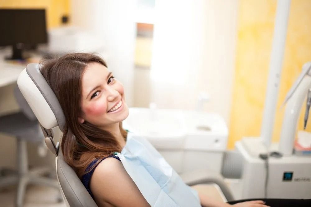 Woman Smiling in a Dentist's Chair, Waiting — Tamworth Orthocare In Gunnedah, NSW