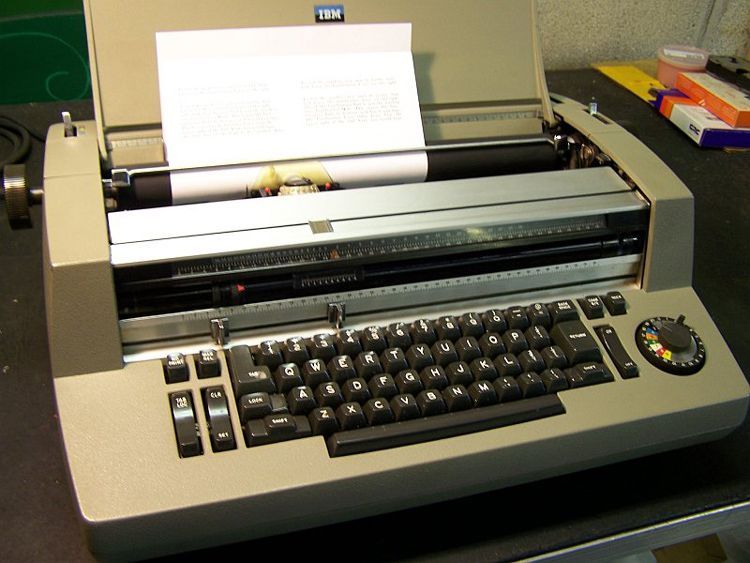 An ibm typewriter with a piece of paper coming out of it