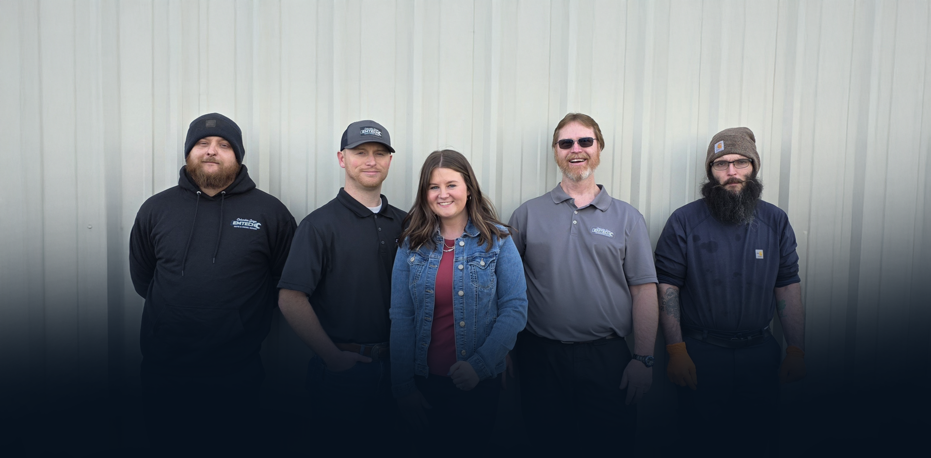 Mechanic working on the undercarriage of a car in a garage.