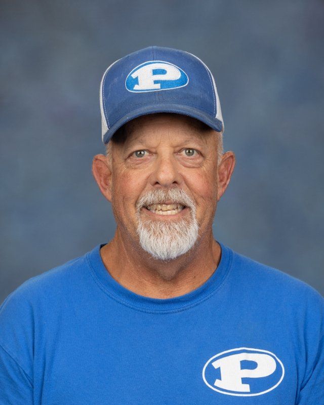 a man wearing a baseball cap and a blue shirt with the letter p on it