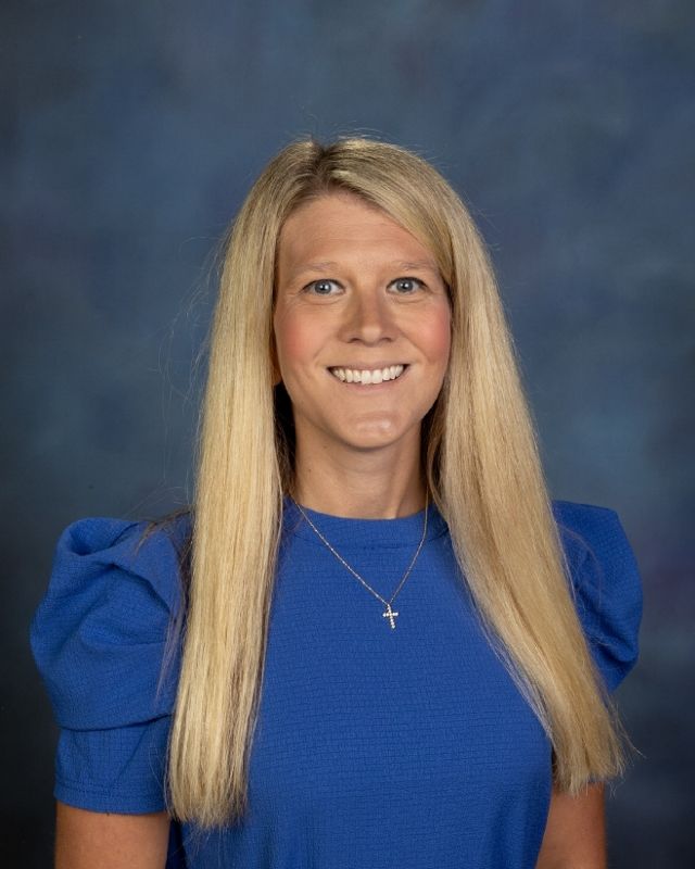 a woman in a floral shirt is smiling for the camera .