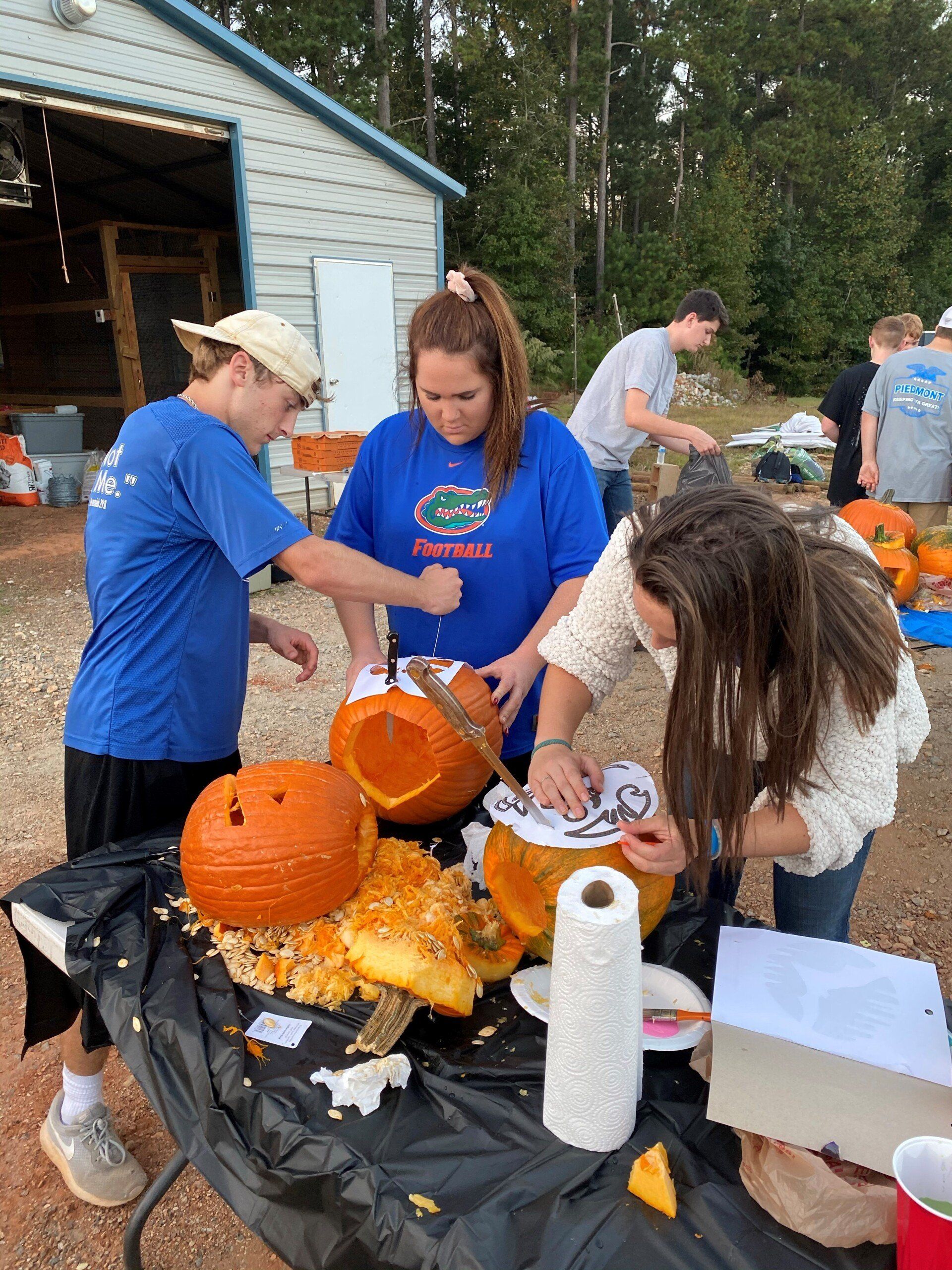 a group of people are carving pumpkins on a table .