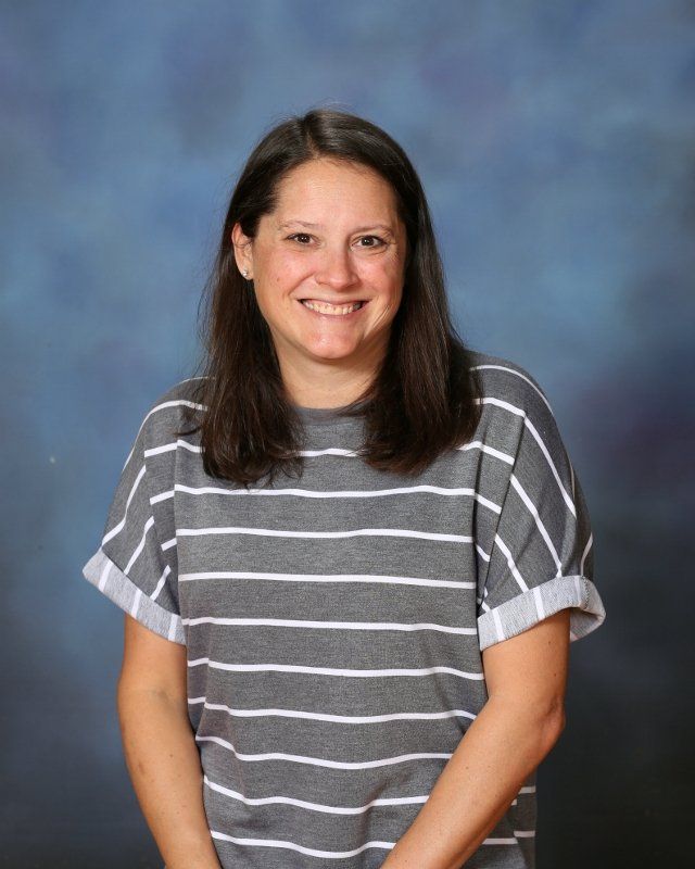 the woman is wearing a striped shirt and smiling for the camera .