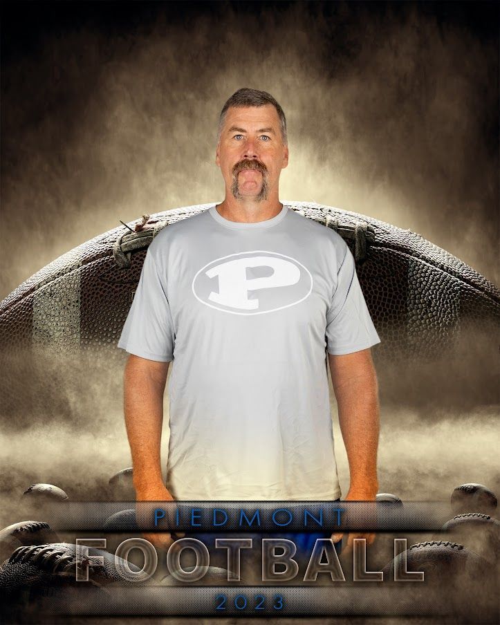 a man in a grey shirt with the letter p on it is standing in front of a football .