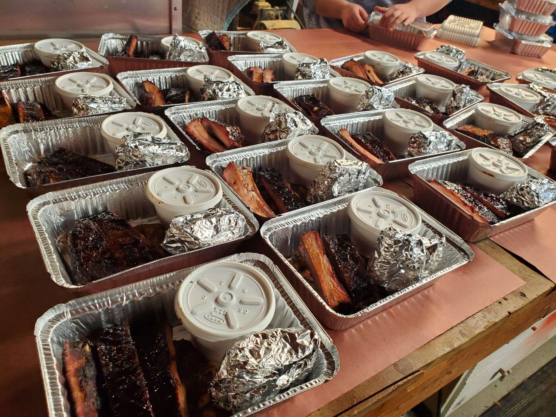 A table full of aluminum foil containers filled with food