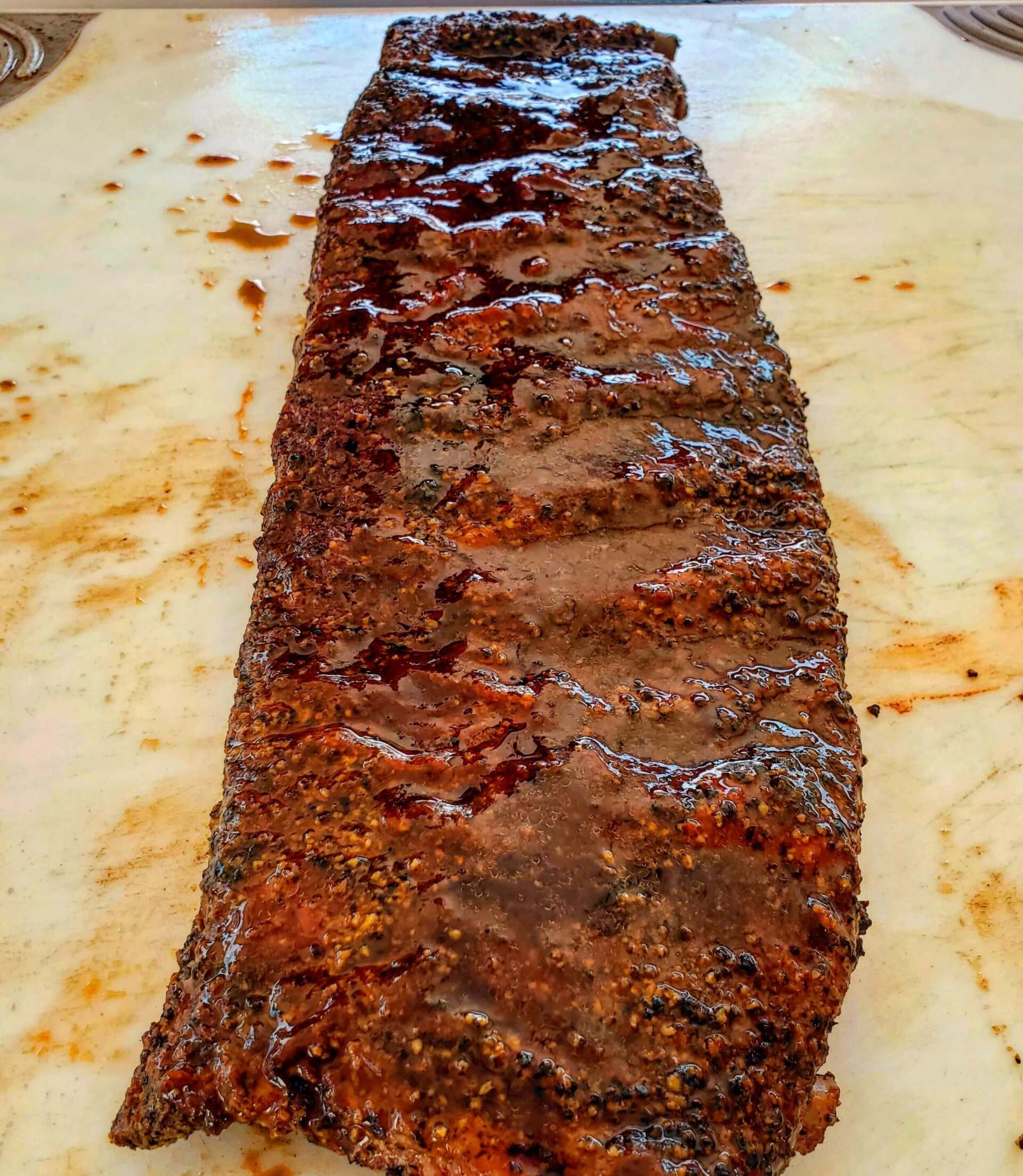 A large piece of meat is sitting on a cutting board