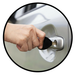 A person's hand inserts a key into a silver car door lock.