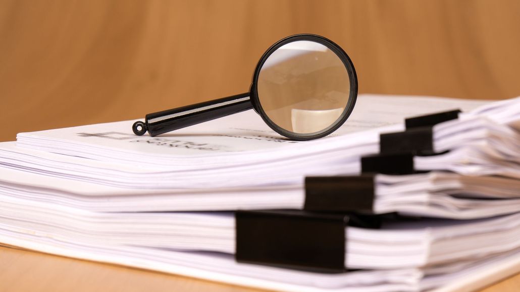 Magnifying Glass on A Stack of White Papers — Birmingham, AL — Magic City Investigations, LLC Magnifying Glass on A Stack of White Papers — Birmingham, AL — Magic City Investigations, LLC
