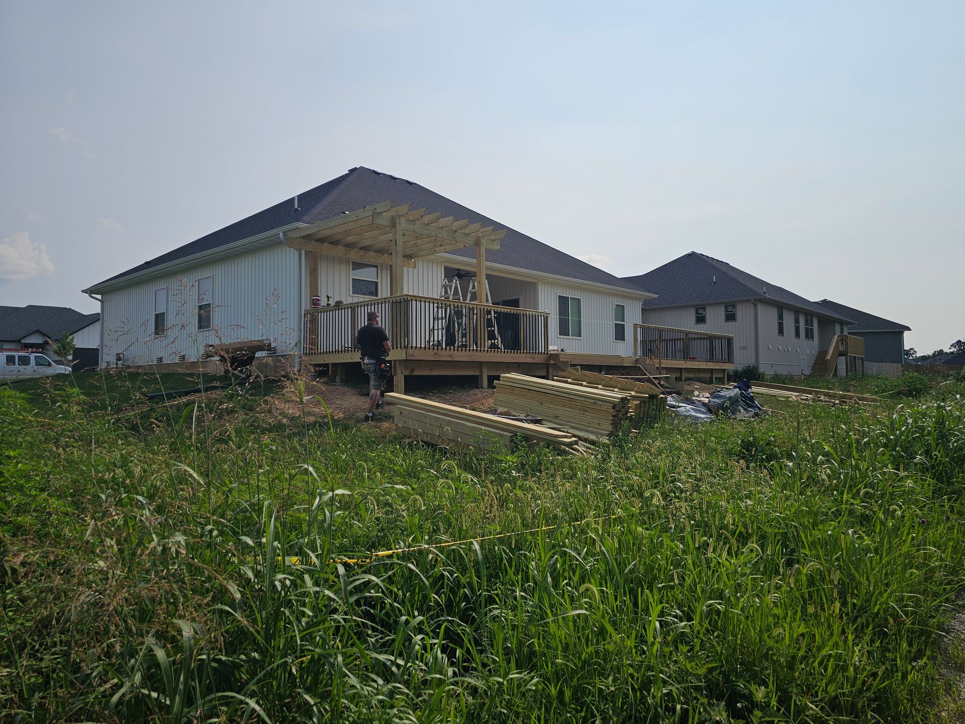 House with deck under construction in tall grass.