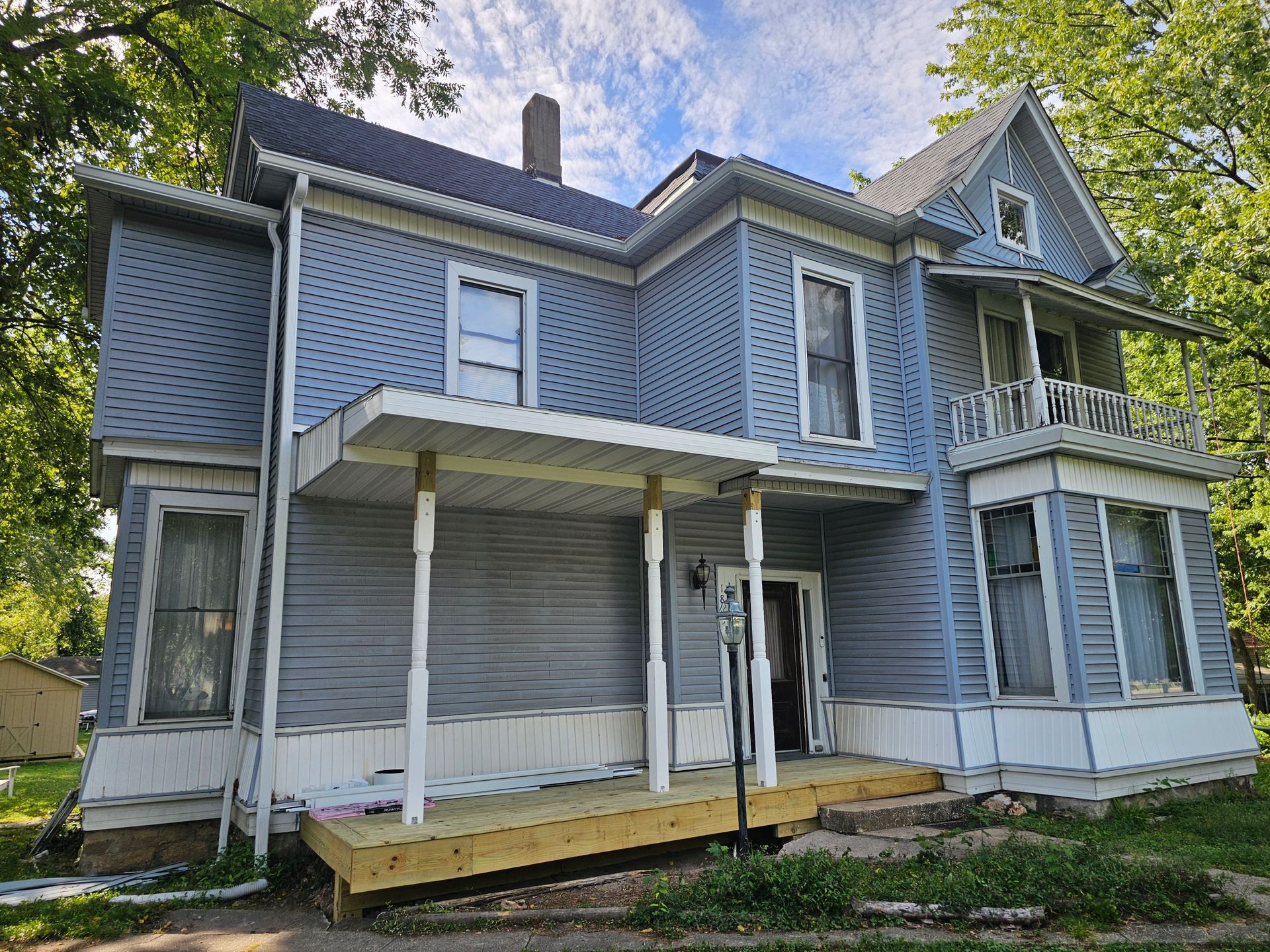 Two-story blue house with white trim and a porch.