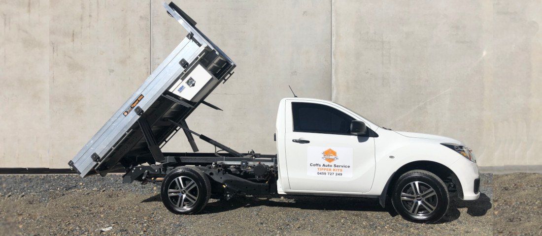 A White Dump Truck is Parked in Front of a Concrete Wall— Coffs Auto Service in North Boambee Valley, NSW