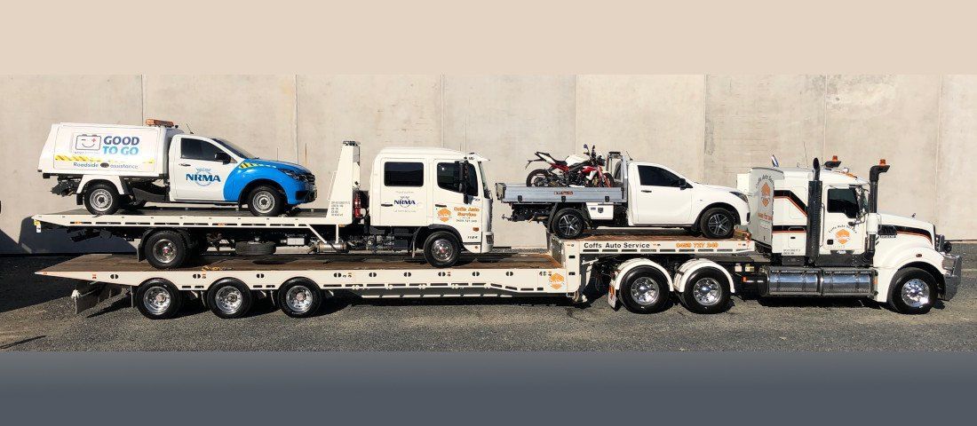 A Row of Tow Trucks With Cars on the Back of Them — Coffs Auto Service in North Boambee Valley, NSW