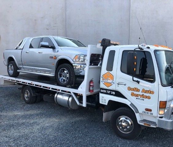 A Silver Truck is Being Towed by a Tow Truck — Coffs Auto Service in North Boambee Valley, NSW