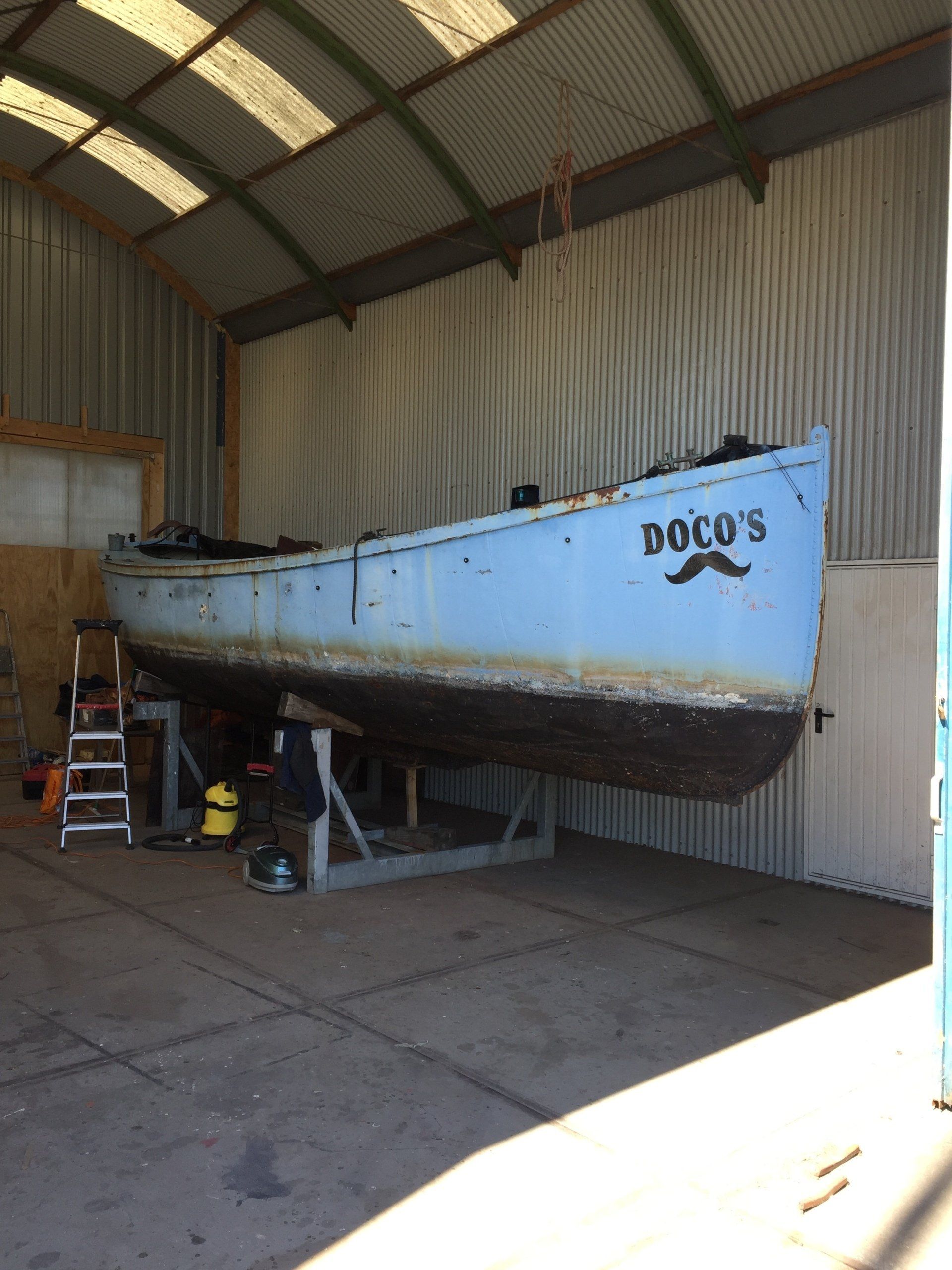neglected boat on stands in a workshop