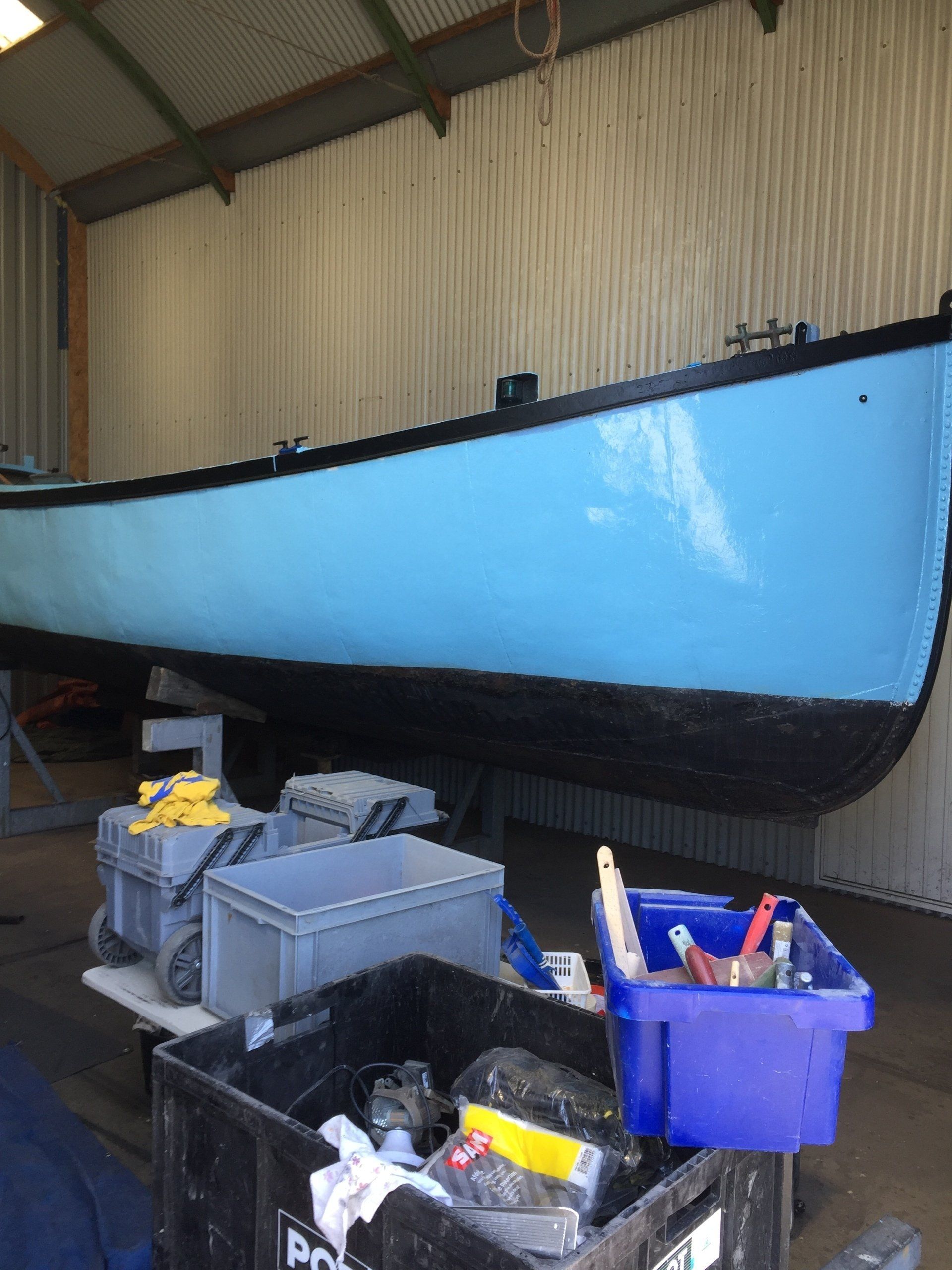 boat on stands in a workshop outer hull painted blue