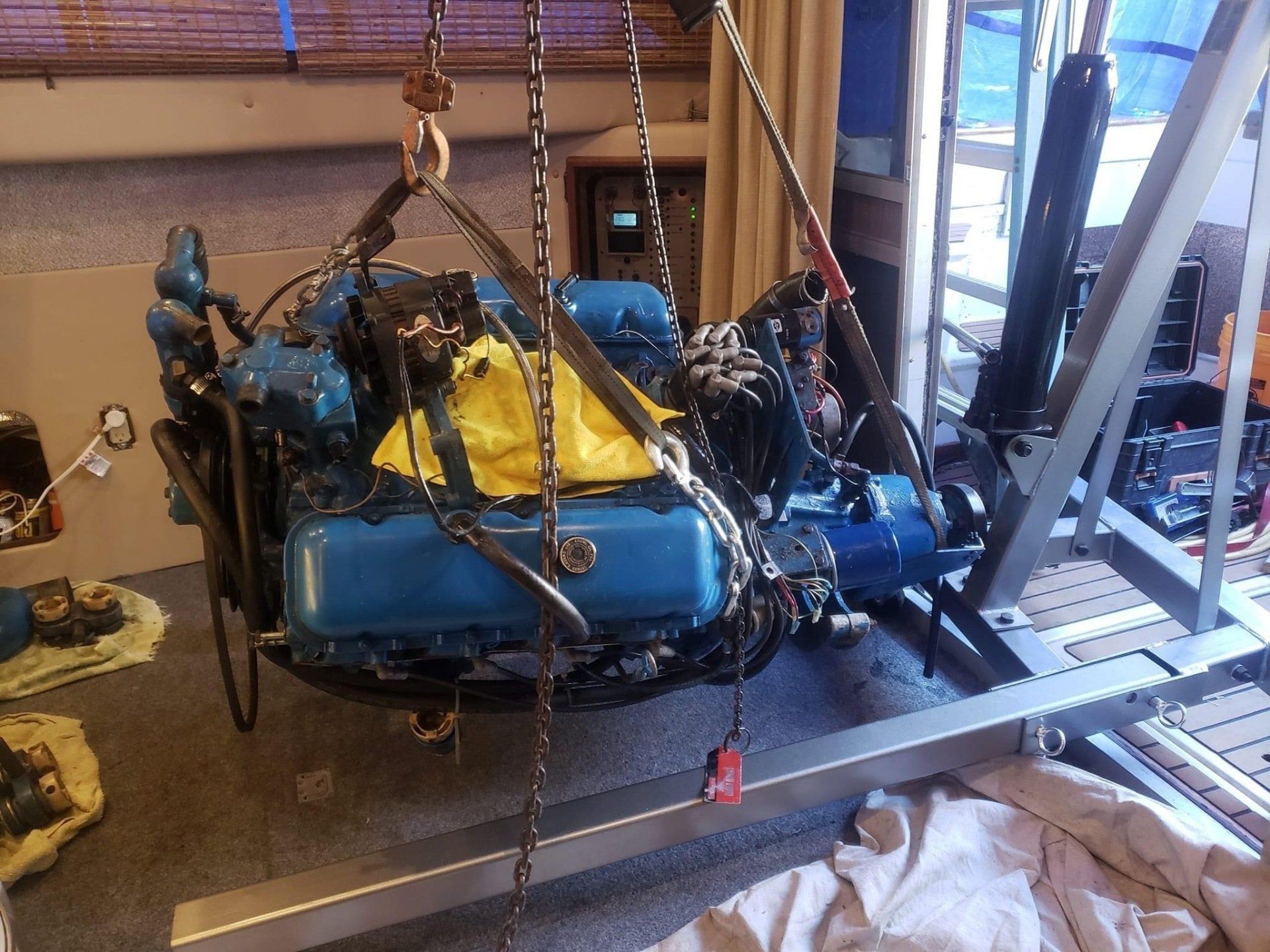 a boat engine hanging on chains from a engine crane