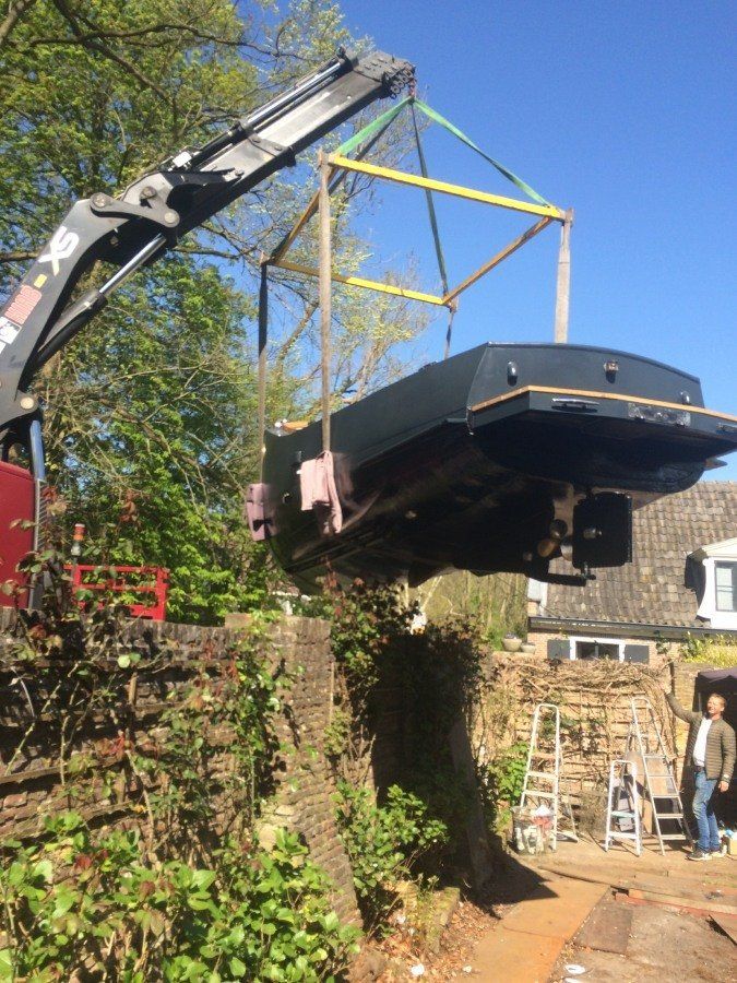 a boat named Michiel de Ruyter fully restored, being hoisted back into the water