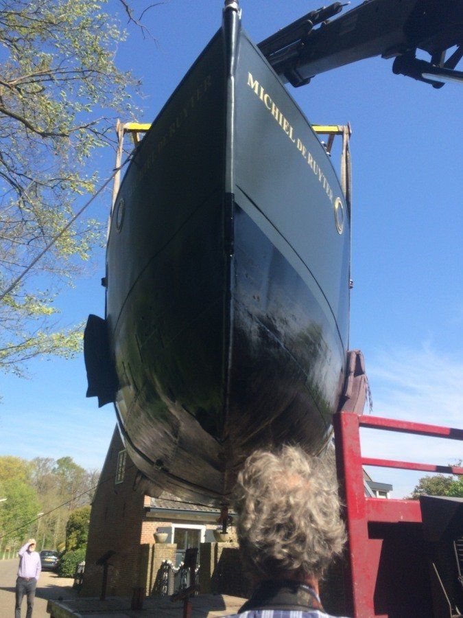 a boat named Michiel de Ruyter fully restored, being hoisted back into the water