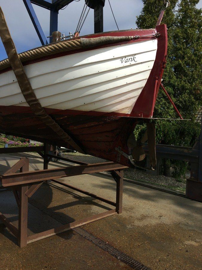 wooden sloop hauled out of the water to be restored