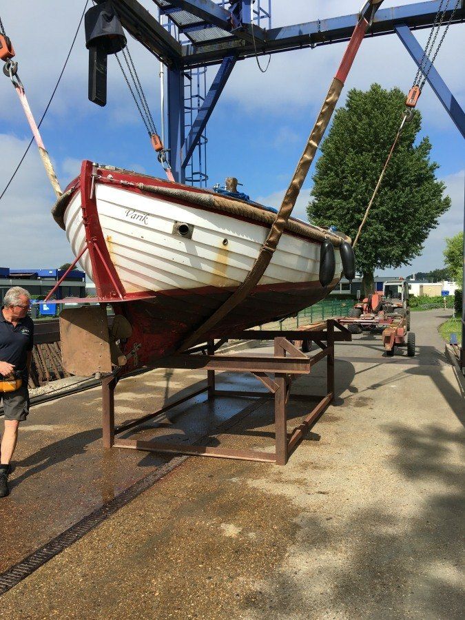 wooden sloop hauled out of the water to be restored