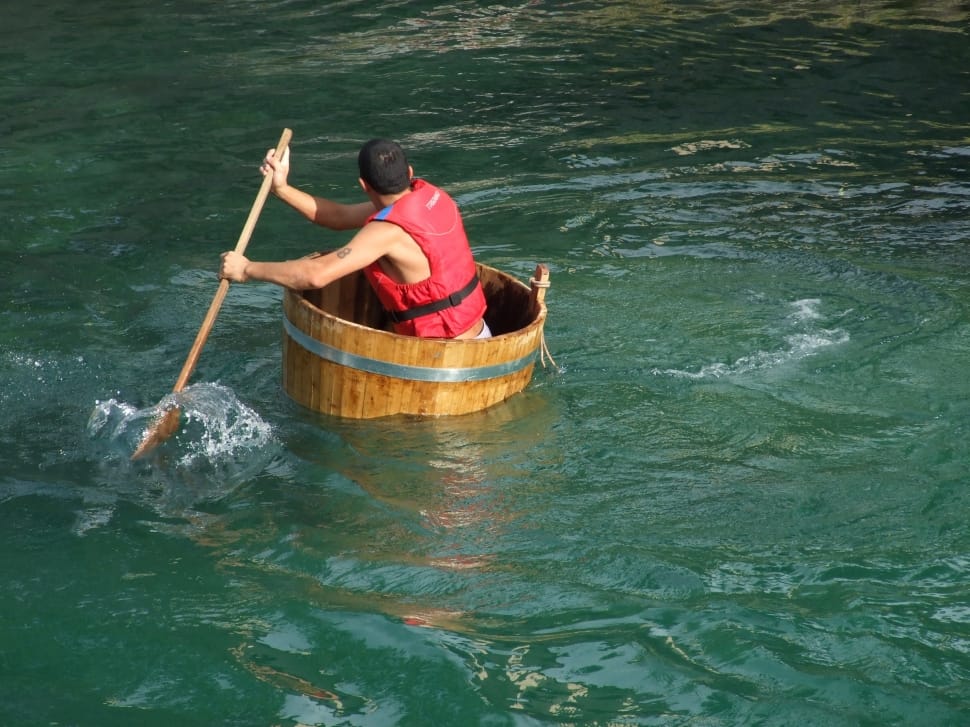 man in a tub rowing in the water to denote water safety