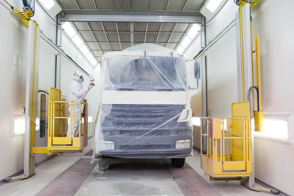 Service Truck Being Painted With Plastic Cover — Almont, MI — Paul’s Collision and Towing Paul’s Truck Center