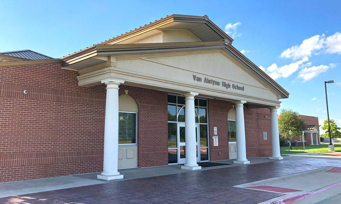 Van Buren High School building with brick exterior, white columns, and a blue sky.