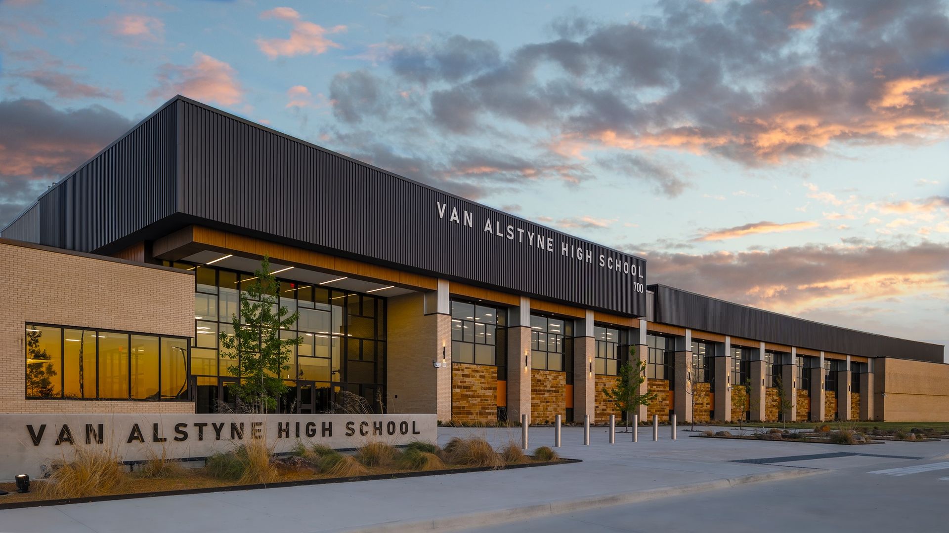 Van Alstyne Elementary School entrance with stone facade and red trim under a blue sky.