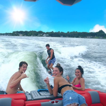 A man wakesurfing while posing with a group