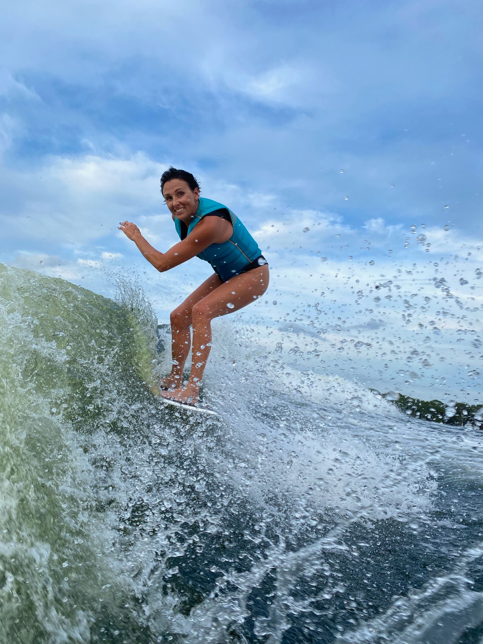 A woman is riding a wave on a surfboard in the ocean.