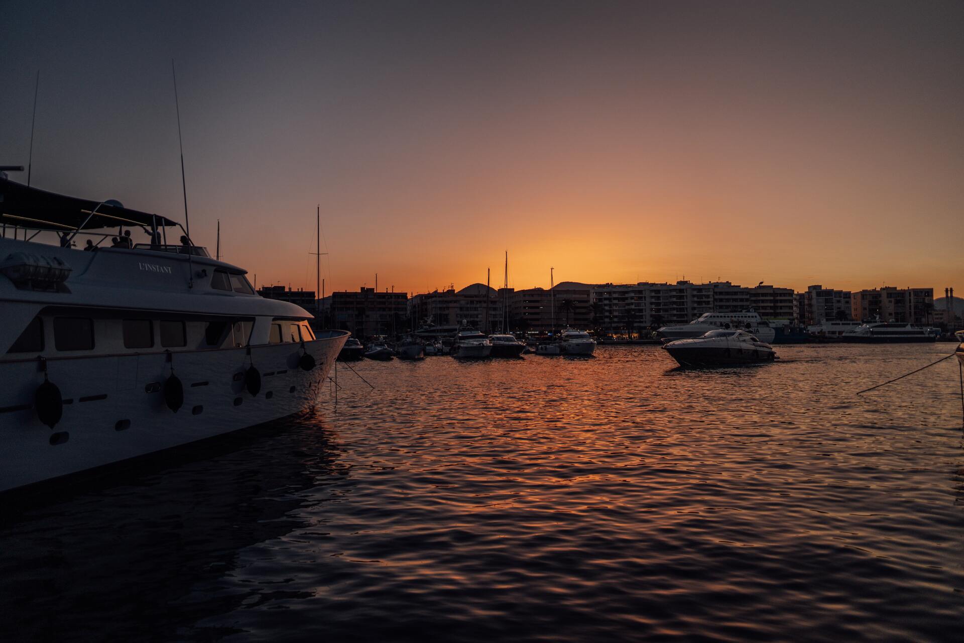 A boat is docked in a harbor at sunset.