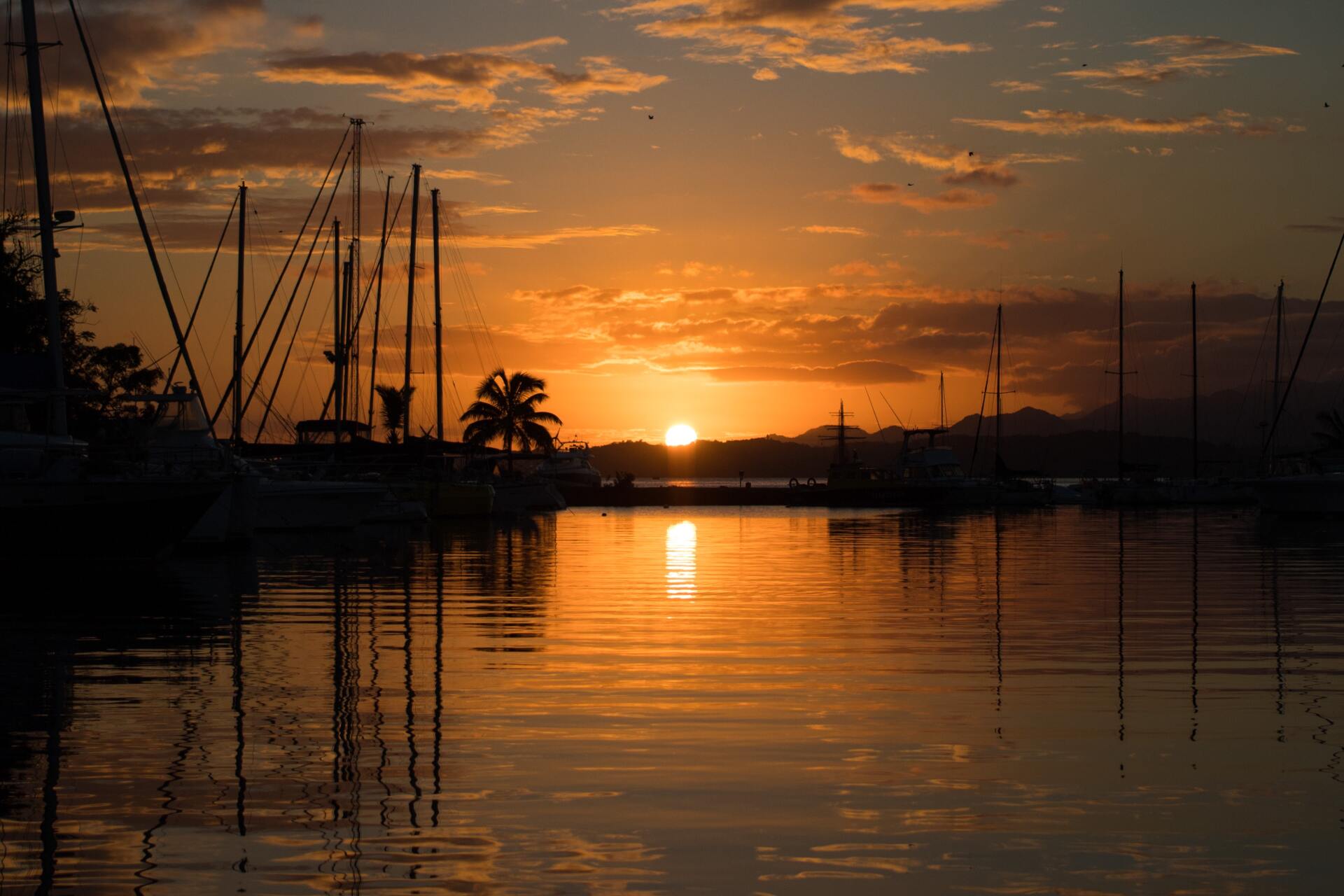 A sunset over a harbor with boats docked in the water.