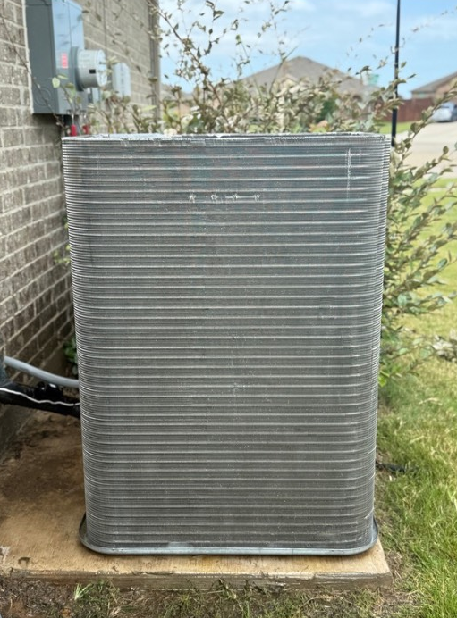 Outdoor air conditioning unit next to a brick wall.