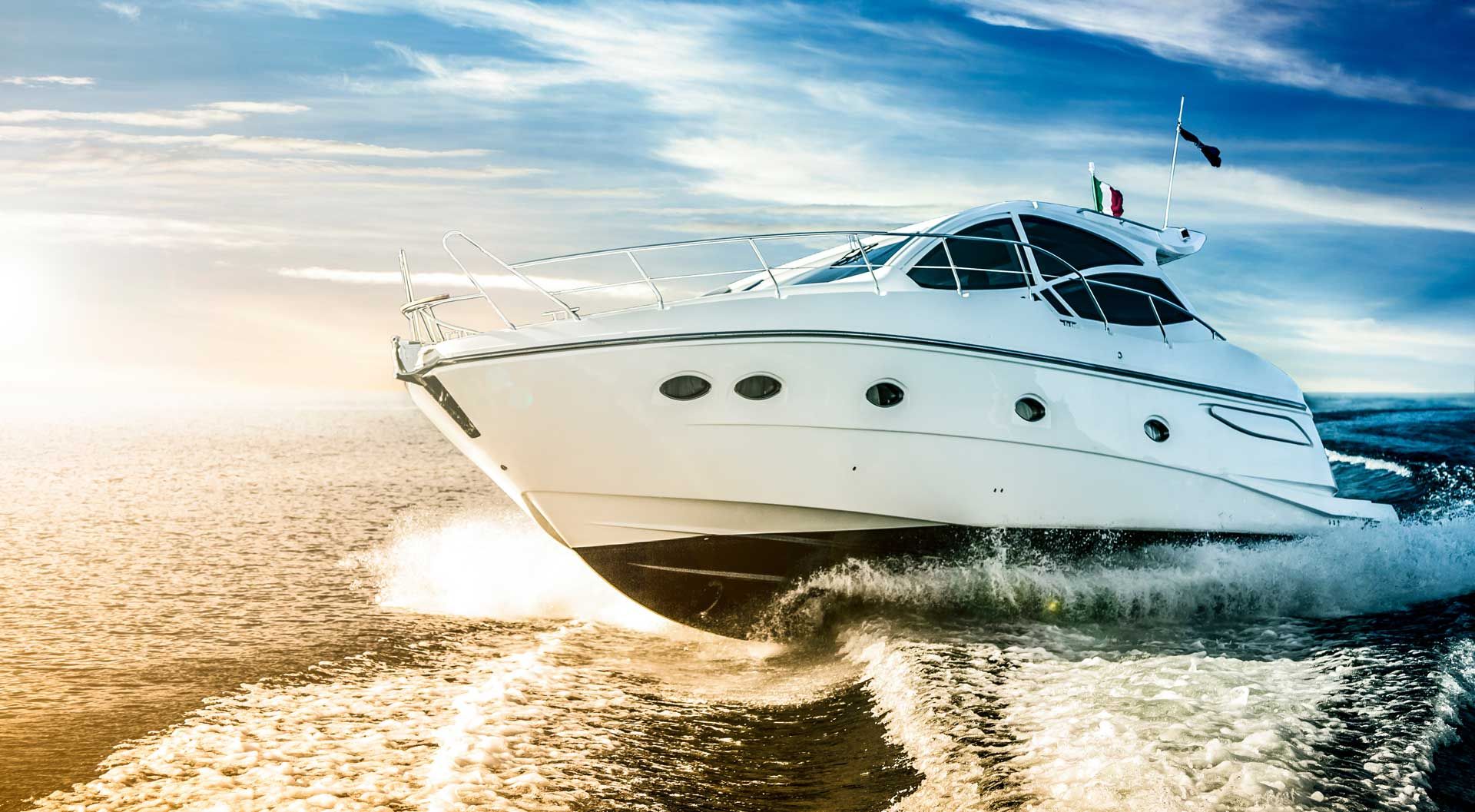 White motorboat speeding across the water, sunlit sky, splashing waves.