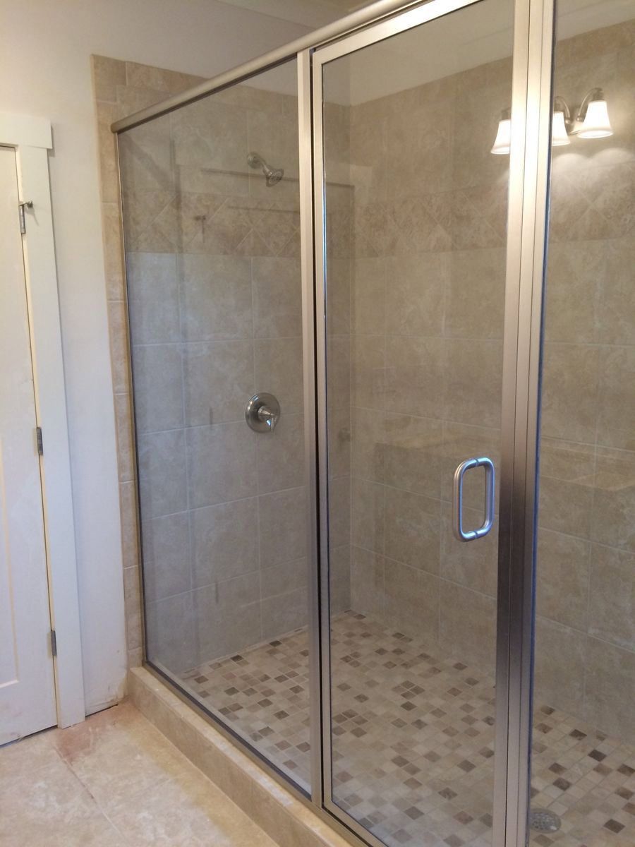 A bathroom with a sliding glass shower door