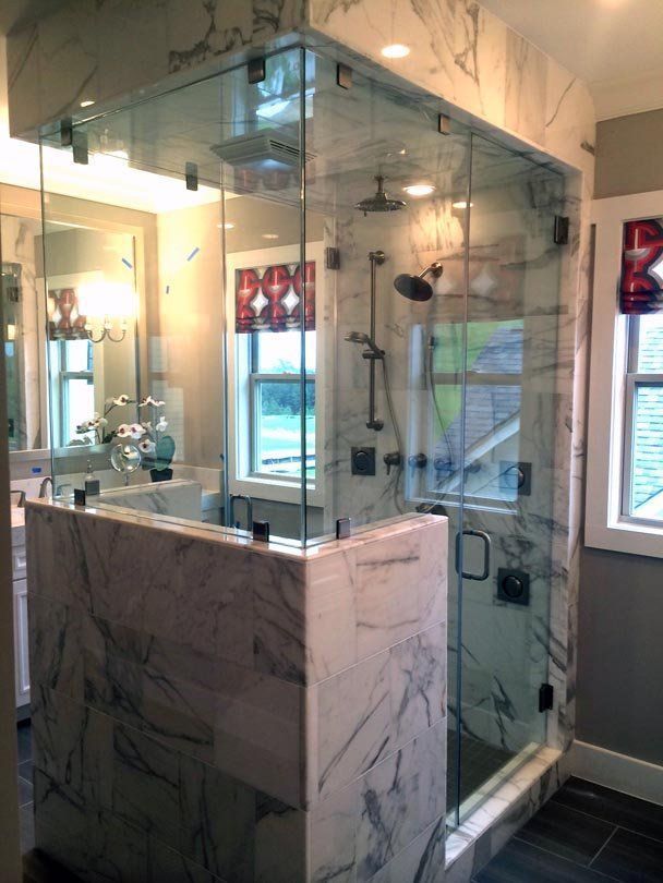 A bathroom with a walk in shower and a sink